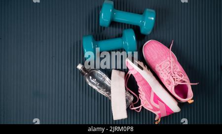 Fitness-Kit - Kurzhanteln mit Sneakern, Flasche Wasser, Handtuch und Buff Stockfoto