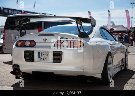 Das Heck eines weißen Toyota Supra der vierten Generation mit einem Kohlefaserspoiler, der auf einer Straße geparkt ist Stockfoto