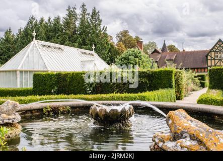 Der Zierbrunnen und die grünen Häuser im Hintergrund der Eythrope Gardens auf dem Landgut Waddesdon. Stockfoto