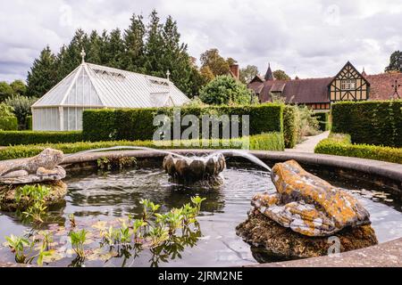 Der Zierbrunnen und die grünen Häuser im Hintergrund der Eythrope Gardens auf dem Landgut Waddesdon. Stockfoto