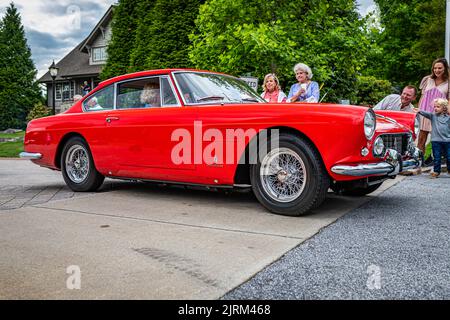 Highlands, NC - 10. Juni 2022: Low-Perspective-Seitenansicht eines 1962 Ferrari 250 GTE 2+2 Series II Coupés, das eine lokale Automobilausstellung verlässt. Stockfoto