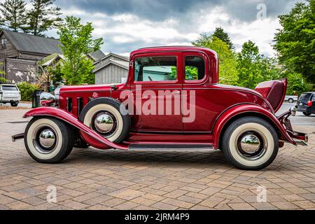 Highlands, NC - 10. Juni 2022: Low-Perspective-Seitenansicht eines Chevrolet Rumble Seat Coupés aus dem Jahr 1932 auf einer lokalen Automobilmesse. Stockfoto