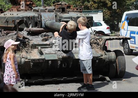 ODESA, UKRAINE - 25. AUGUST 2022 - Kinder erkunden eines der russischen Militärfahrzeuge, die von den Streitkräften der Ukraine zerstört wurden und auf dem Me ausgestellt sind Stockfoto