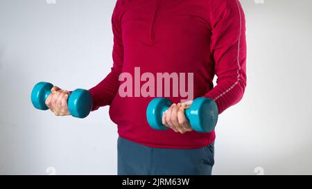 Mann mit Kurzhanteln - Sporttraining, Muskeln pumpen Stockfoto