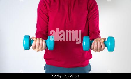Sportlicher Mann mit Kurzhanteln in den Händen zum Training Stockfoto