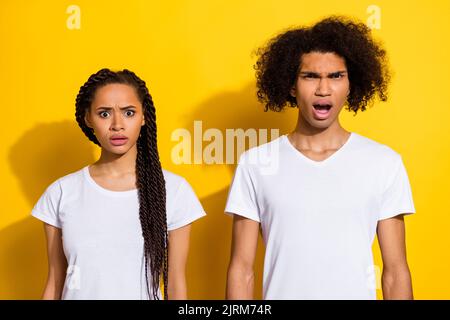 Foto von zwei beeindruckt unzufriedenen Menschen starren sprachlos isoliert auf gelbem Hintergrund Stockfoto