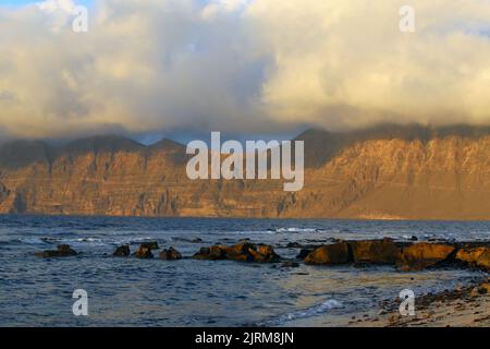 Blick auf den Risco de Famara vom Strand San Juan bei Sonnenuntergang Stockfoto