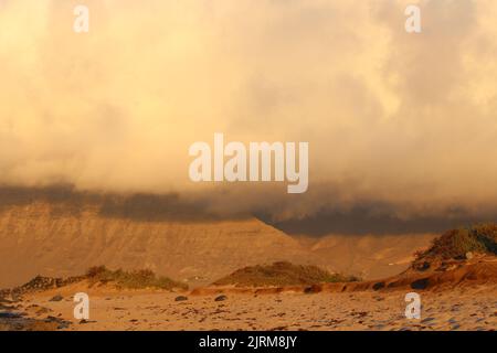 Blick auf den Risco de Famara vom Strand San Juan bei Sonnenuntergang Stockfoto