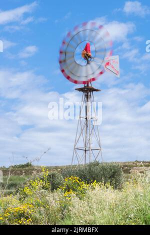 Eine funktionsfähige Windpumpe mit rotierendem Rotor mit mehreren Lamellenscheiben in Bewegung, die zur Wassergewinnung in der Landwirtschaft auf der Insel Gozo auf den maltesischen Inseln verwendet wird Stockfoto