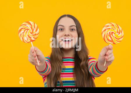 Hipster Teenager Kind Mädchen lecken Lollypop. Zucker Ernährung, Süßigkeiten und Süßigkeiten. Kind isst Lollipop-Popsicle. Stockfoto