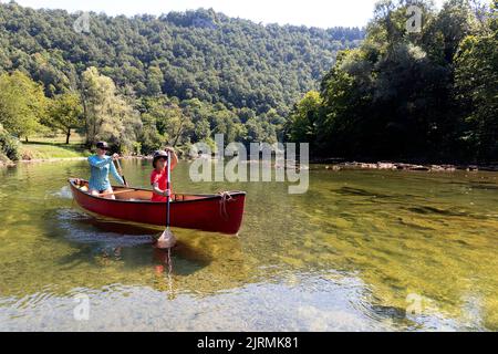 Touristen, Mutter und Sohn auf einer Kanufahrt im Sommer auf einem wunderschönen Fluss Kolpa, dem Grenzfluss zwischen Slowenien und Kroatien, Slowenien Stockfoto