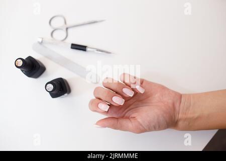 Maniküre oder Pediküre liefert Werkzeuge und Hand auf dem Tisch. Stockfoto