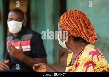 Ältere afrikanische Frau und junger afrikanischer Mann mit Gesichtsmasken Stockfoto
