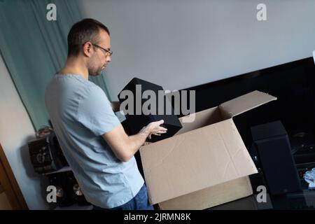 Erwachsener Mann Kleinunternehmen Besitzer Verpackung Verpackung Paket Versand an Kunden. Unternehmer Verpackung Box für die Lieferung zu Hause. Stockfoto