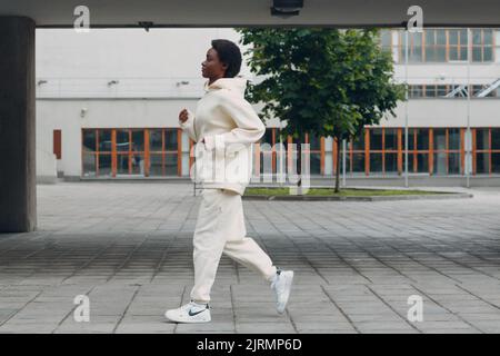 Afroamerikanische Läuferin Frau im Hoodie beim Joggen im Freien. Stockfoto