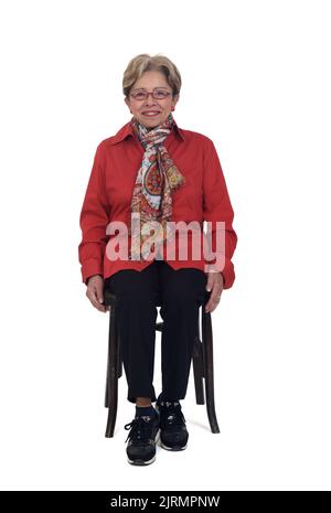 Ältere Frau sitzt auf einem Stuhl auf weißem Hintergrund Stockfoto