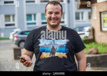 Danzig, Polen. 24. August 2022. Danzig, Polen August 25.. 2022 Mann mit einem T-Shirt mit ukrainischer Briefmarke und Soldat, der den Finger auf das Moscow-Kriegsschiff zeigt, während der Feierlichkeiten zum Unabhängigkeitstag der Ukraine in Danzig zu sehen ist, Polen am 24. August 2022 der 24.. August ist in diesem Jahr ein besonderer Tag, denn genau 6 Monate vergehen an diesem Tag für den barbarischen Angriff von Putins Russland auf die Ukraine. Quelle: Vadim Pacajev/Alamy Live News Stockfoto