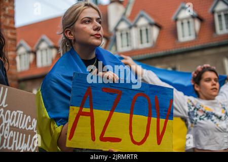 Danzig, Polen. 24. August 2022. Danzig, Polen August 25.. 2022 Ukrainischer Kriegsflüchtling mit Transparent, das Asow während des Unabhängigkeitstages der Ukraine spricht, wird in Danzig gesehen, Polen am 24. August 2022 der 24.. August ist in diesem Jahr ein besonderer Tag, denn genau 6 Monate vergehen an diesem Tag für den barbarischen Angriff von Putins Russland auf die Ukraine. Quelle: Vadim Pacajev/Alamy Live News Stockfoto