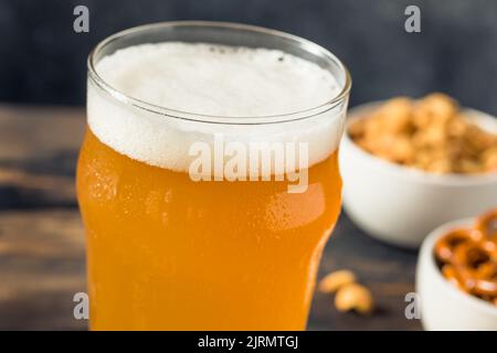 Kaltes, erfrischendes Oktoberfest-Bier mit Pretzels und Nüssen Stockfoto