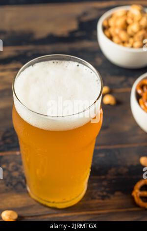 Kaltes, erfrischendes Oktoberfest-Bier mit Pretzels und Nüssen Stockfoto