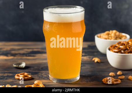 Kaltes, erfrischendes Oktoberfest-Bier mit Pretzels und Nüssen Stockfoto