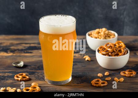 Kaltes, erfrischendes Oktoberfest-Bier mit Pretzels und Nüssen Stockfoto