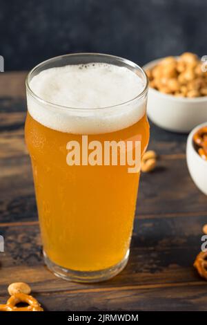 Kaltes, erfrischendes Oktoberfest-Bier mit Pretzels und Nüssen Stockfoto