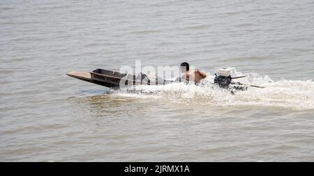 SAMUT PRAKAN, THAILAND, APR 01 2022, Ein thailänder fährt ein schnelles Boot mit typisch langem Schwanz am Meer Stockfoto