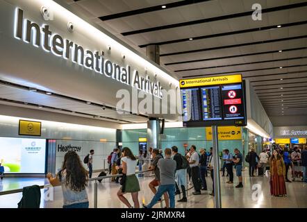 Am Flughafen Heathrow, dem verkehrsreichsten Flughafen Großbritanniens, warten Menschen an den internationalen Ankünften im Terminal 2. Heathrow sagt, dass die Anzahl der Passagiere und die im letzten Monat verhängten Flugausfälle dazu beigetragen haben, schwere Staus und Verspätungen zu verringern. Nach der Pandemie von Covid-19 fehlten in Heathrow trai8nsed Mitarbeiter, und die Sicherheitskräfte wurden geräumt, sodass viele Passagiere mit massiven Verspätungen konfrontiert waren und ihr Gepäck verloren ging. Stockfoto
