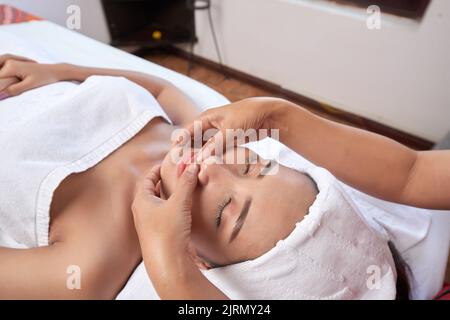 Junge asiatische Frau mit entspannenden Gesichtsmassage im Spa-Salon Stockfoto
