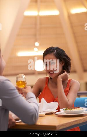 Schöne junge vietnamesische Frau mit Abendessen mit ihrem Freund Stockfoto