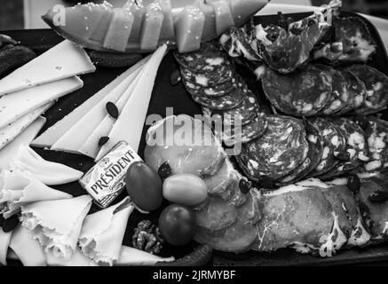 Salami- und Käseplatte mit President Butter in der traditionellen französischen Bar. President ist eine französische Milchmarke, die 1933 gegründet wurde. Schwarzweißfoto Stockfoto