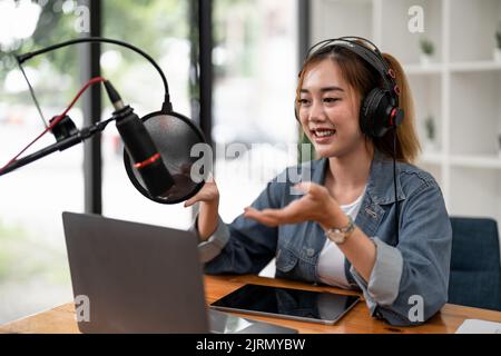 Junge asiatische Frau macht einen Podcast Audio-Aufnahme zu Hause. Stockfoto