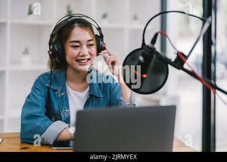 Junge asiatische Frau macht einen Podcast Audio-Aufnahme zu Hause. Stockfoto