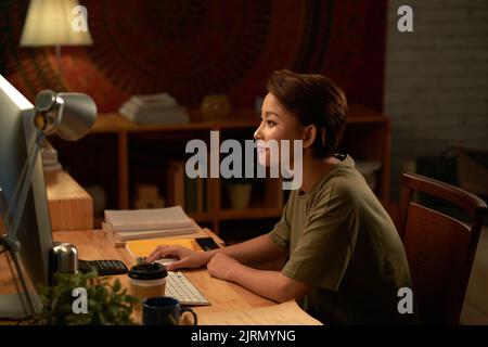 Hübsche junge Vietnamesin, die nachts studiert Stockfoto