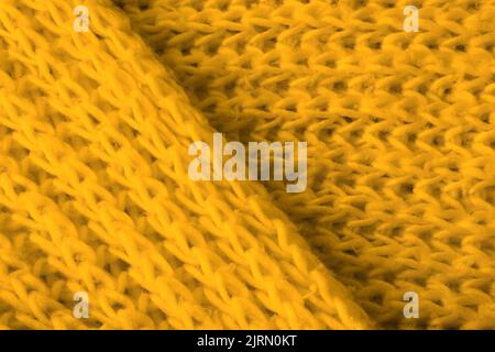 Struktur aus weichem gelbem Strickstoff als Hintergrund. Banner für Design Stockfoto