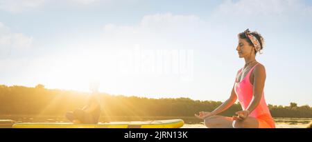Frau und Mann meditieren während eines ruhigen Sommermorgens Stockfoto