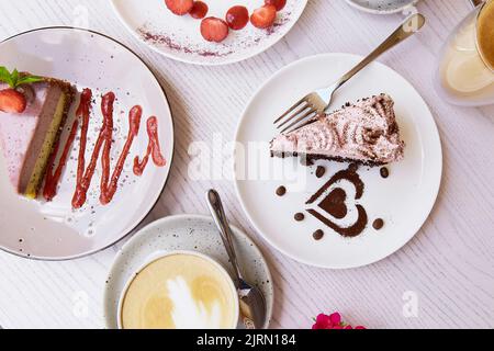 Natürliche vegane, gesunde, geschichtete Desserts, ein Stück Kuchen mit frischen Früchten und Beeren draußen. Feier, Süßigkeitenauswahl auf der Terrasse. Stockfoto