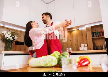 Breites Banner Panoramablick auf überglücklich jungen kaukasischen Mann und Frau haben Spaß beim Tanzen in der modernen Küche zu Hause. Stockfoto