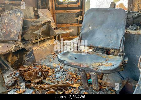 Verbrannte Sitze in verlassenen ausgebrannten Fahrzeugen, verkohltem Innenraum. Feuer beschädigt auf der Stadtstraße, Vandalismus oder Kämpfe während des Krieges. Nahaufnahme. Stockfoto