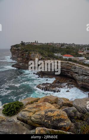 Eine Luftaufnahme von Meereswellen, die Klippen in Sydney brechen Stockfoto