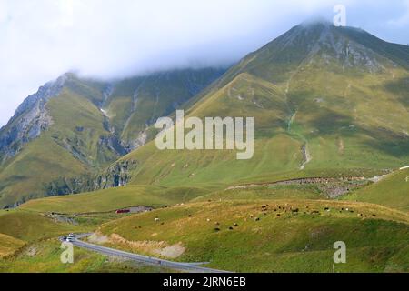 Sonnender Panoramablick auf den Georgian Military Highway auf der Great Caucasus Mountain Range, Gudauri Town, Georgien Stockfoto