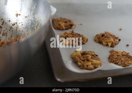 Gebackene Plätzchen auf einem Backblech. Metallschüssel. Wohnküche Stockfoto