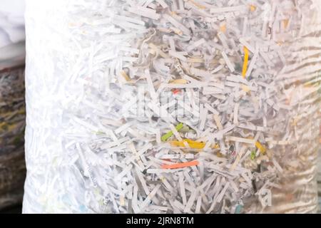 Zerfetzte Papierfetzen in einer Tasche, Dokumente für die Privatsphäre zerstört. Stockfoto