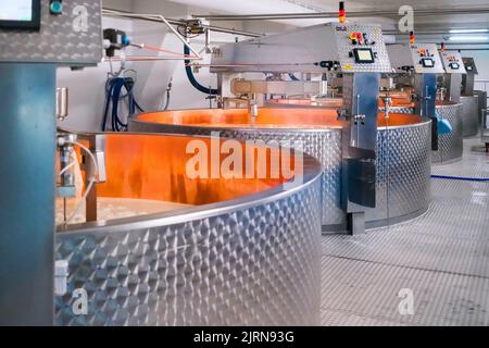 Albertville , Frankreich - 20. August 2022: Bottiche mit frischer Milch in der industriellen Käse- und Molkenproduktion. Stockfoto