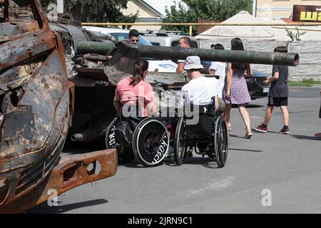 Non Exclusive: ODESA, UKRAINE - 25. AUGUST 2022 - Ein Mann und eine Frau mit Behinderungen schauen sich eines der russischen Militärfahrzeuge an, die von der Armee zerstört wurden Stockfoto