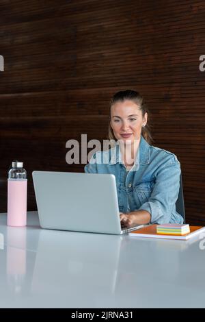 Junge Frau, die im Büro in einer denkenden Stimmung arbeitet - Stock photo Stockfoto