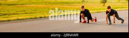 Fit Athlet Laufrennen in Leichtathletik Rennstrecke an einem sonnigen Tag. Schöner Feldhintergrund. Stockfoto