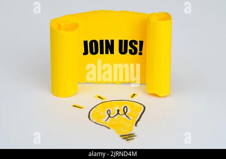Geschäftsidee-Konzept. Eine Glühbirne ist auf weißem Hintergrund gezeichnet, daneben ist eine gelbe Tafel mit der Aufschrift - JOIN US Stockfoto