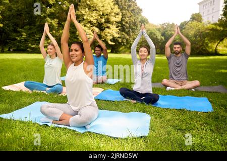 Eine Gruppe von Menschen, die im Sommerpark Yoga machen Stockfoto